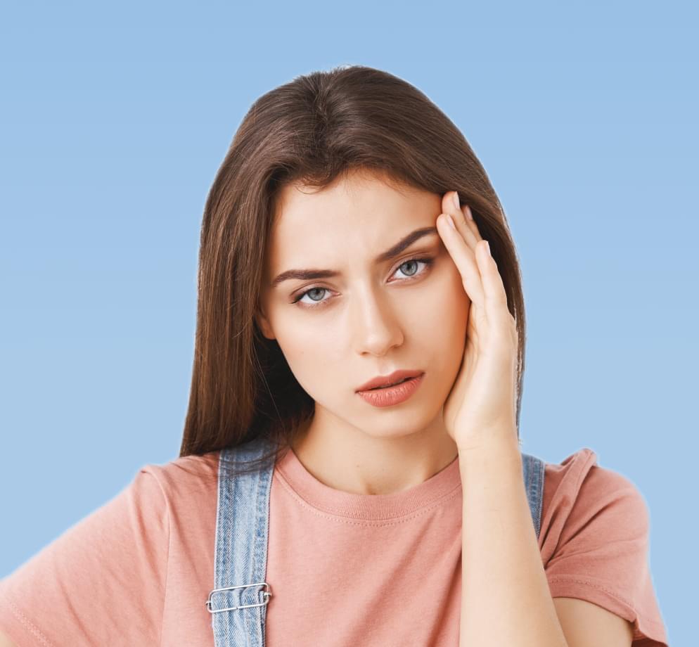 Уставшая девушка держится за голову